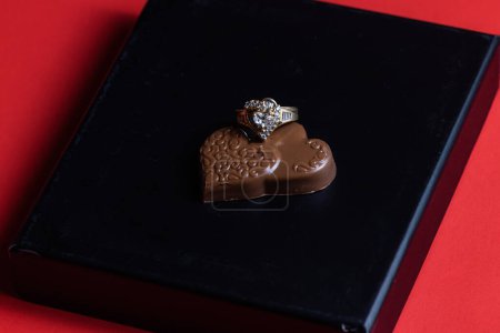 Téléchargez les photos : Heart shaped ring with chocolates on a black box lid - en image libre de droit