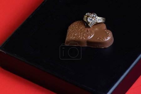 Téléchargez les photos : Heart shaped ring with chocolates on a black box lid - en image libre de droit