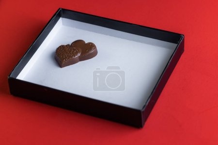 Téléchargez les photos : Heart shaped ring with chocolates inside of a white lid with red all around - en image libre de droit