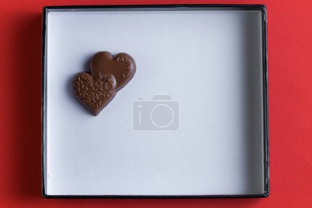 Téléchargez les photos : Heart shaped ring with chocolates inside of a white lid with red all around - en image libre de droit