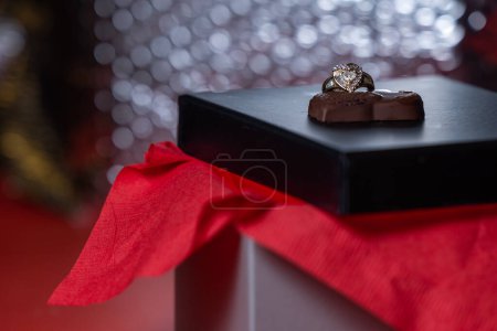 Photo for Heart shaped ring with chocolates on a black box lid - Royalty Free Image