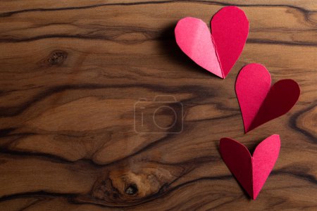Photo for Close up of small heart shaped cut outs on a wooden table with a beautiful texture - Royalty Free Image
