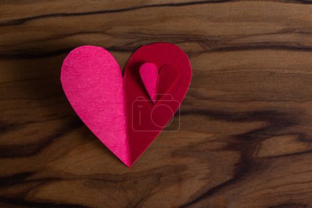 Photo for Close up of small heart shaped cut out on a wooden table with a beautiful texture - Royalty Free Image