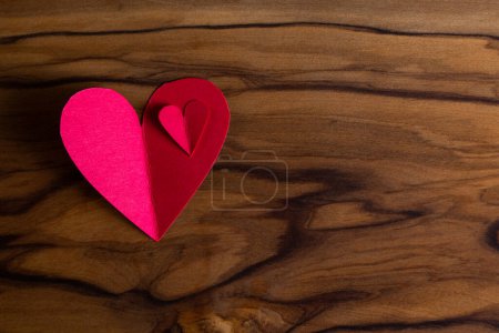 Téléchargez les photos : Close up of small heart shaped cut out on a wooden table with a beautiful texture - en image libre de droit