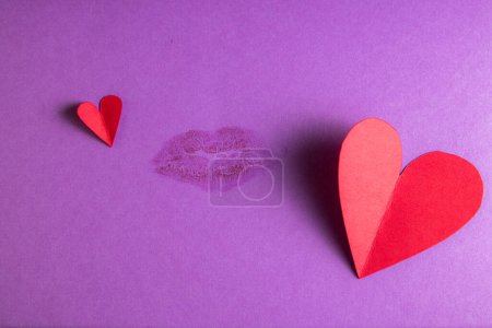 Téléchargez les photos : Concept for a love note with hand cut hearts and a kiss - en image libre de droit