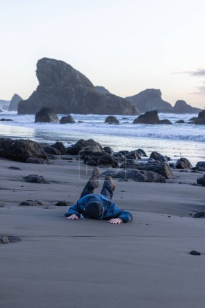 Téléchargez les photos : Man in his thirties having chest pain while walking on the beach - en image libre de droit