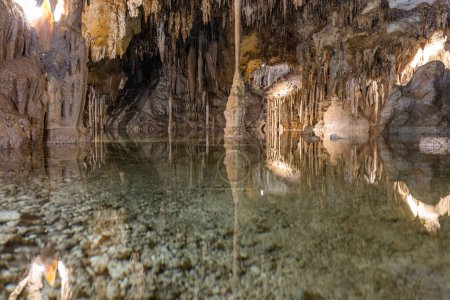 Téléchargez les photos : Piscine souterraine aux reflets calmes avec stalactites suspendues au plafond à l'intérieur des grottes Lehman dans le parc national du Grand Bassin - en image libre de droit