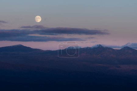 Foto de Primer plano de la Superluna de la Cosecha subiendo sobre el Parque Nacional del Lago del Cráter visto desde la distancia - Imagen libre de derechos