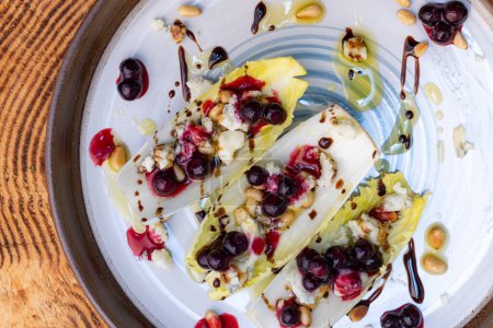 Photo for Vegetarians appetizer made with fresh Belgium endive boats stuffed with toasted pine nuts, bleu cheese, fresh huckleberries and fresh olive oil topped with a balsamic drizzle. - Royalty Free Image