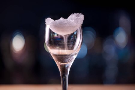 Foto de Primer plano de un vidrio transparente cubierto de hielo con una bebida alcohólica en llamas creando una niebla a partir de las diferentes temperaturas - Imagen libre de derechos