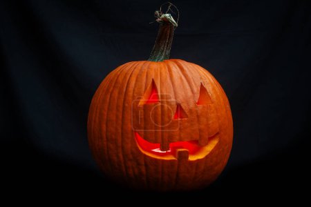 Téléchargez les photos : Gros plan d'une citrouille d'Halloween souriante isolée sur un fond noir - en image libre de droit