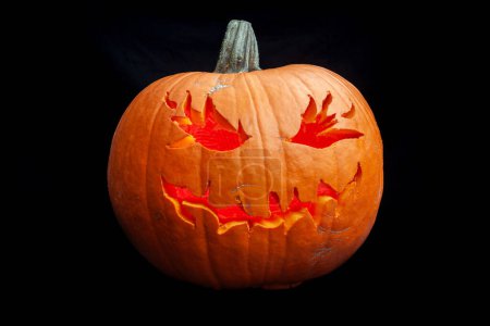 Foto de Primer plano de una calabaza sonriente de halloween aislada sobre un fondo negro - Imagen libre de derechos