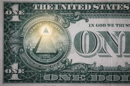 Téléchargez les photos : Gros plan d'une petite section d'un billet d'un dollar montrant l'œil tout voyant et la pyramide avec une lueur. - en image libre de droit