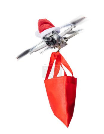 Photo for Drone concept wearing a santa hat and holding a wrapped gift out for delivery isolated on a white background. - Royalty Free Image
