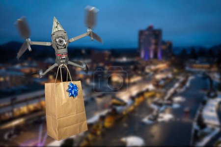 Photo for Close up of a drone wearing a birthday hat delivering a gift flying over a city in the evening. - Royalty Free Image