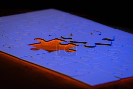 Téléchargez les photos : Gros plan d'un puzzle vierge avec une lumière bleue et orange comme concept. - en image libre de droit