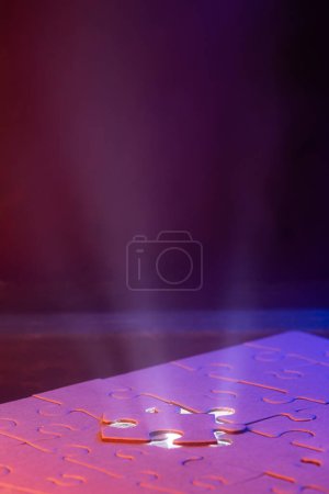 Photo for Close up of a blank puzzle with a blue light and a beam of light from underneath as a concept. - Royalty Free Image