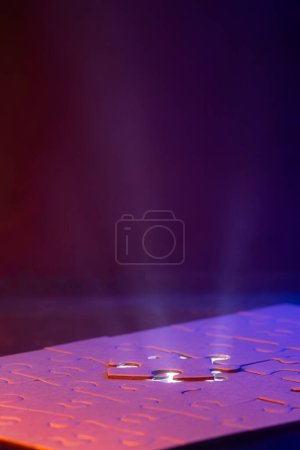 Téléchargez les photos : Gros plan d'un puzzle vierge avec une lumière bleue et un faisceau de lumière d'en dessous comme un concept. - en image libre de droit