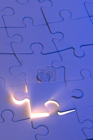 Photo for Close up of a blank puzzle with a blue light and a beam of light from underneath as a concept. - Royalty Free Image