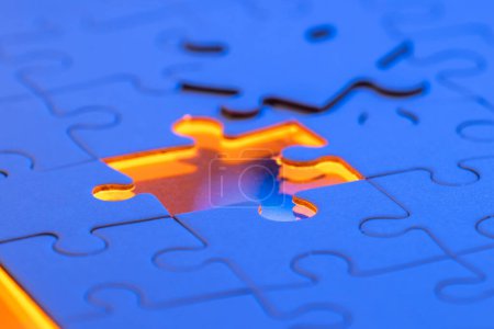 Téléchargez les photos : Gros plan d'un puzzle vierge avec une lumière bleue et orange comme concept. - en image libre de droit