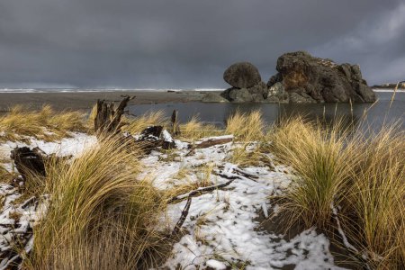 Photo for Turtle rock beach covered in snow after a rare winter storm brought snow to the Southern Oregon coast late February 2023 - Royalty Free Image