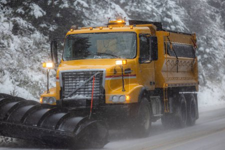 Photo for Snow plow driving on highway 101 in southern Oregon getting ready for a rare snow storm - Royalty Free Image