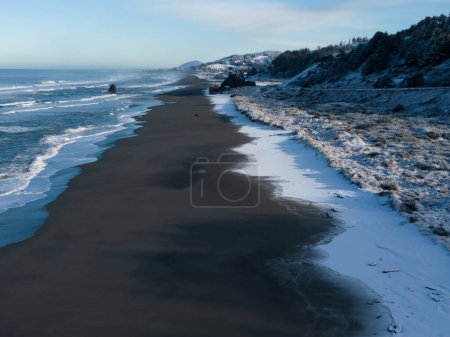 Foto de Parada de playa popular en Gold Beach Oregon conocida como Kissing rock con un paisaje cubierto de nieve debido a una rara tormenta de invierno en febrero de 2023 - Imagen libre de derechos