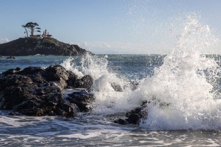 Beautiful view of the Battery Point Lighthouse with waves splashing in the foreground in Crescent City California.