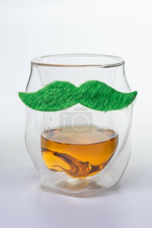 Photo for A glass with a mustache on it. The mustache is green and fuzzy. The glass is filled with a liquid - Royalty Free Image