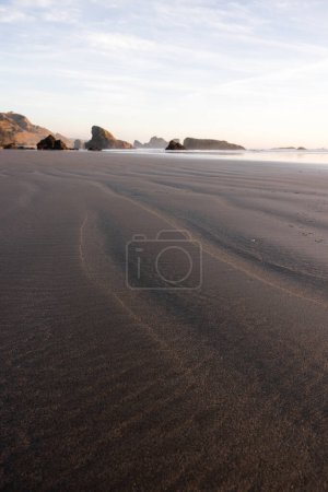 Téléchargez les photos : Une plage avec un rivage rocheux et un ciel nuageux. La plage est vide et les rochers sont éparpillés sur le rivage - en image libre de droit