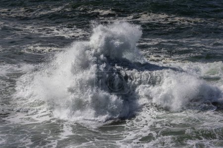 Téléchargez les photos : L'océan est rude et les vagues sont hautes. L'eau est blanche et le ciel est bleu - en image libre de droit