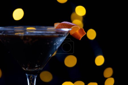 Foto de Una copa de martini con una rebanada de naranja en la parte superior. Concepto de sofisticación y elegancia - Imagen libre de derechos