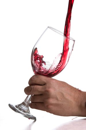 Foto de Acción tiro verter vino tinto en una copa sobre un fondo blanco - Imagen libre de derechos