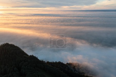 Photo for The sky is filled with clouds and the sun is setting. The clouds are white and fluffy, creating a serene and peaceful atmosphere - Royalty Free Image