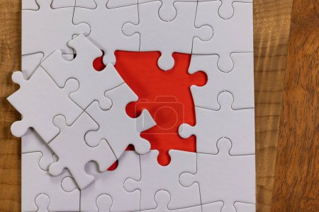 Photo for Blank puzzle with one missing piece next to the whole with a red placer where the last piece belongs. Concept for problem solving. - Royalty Free Image