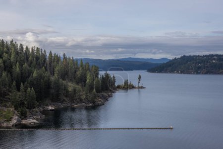 Photo for A beautiful lake with a forest in the background. The sky is cloudy and the water is calm - Royalty Free Image
