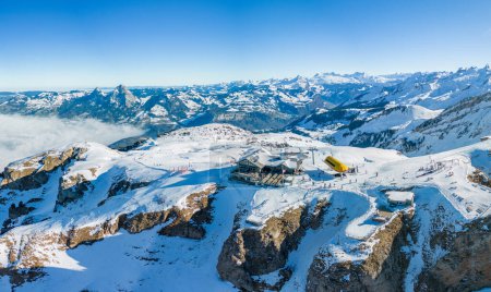 Vista aérea de drones de montañas cubiertas de nieve y pistas de esquí, zona de esquí Stoos, Suiza