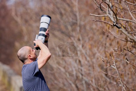 Fotógrafo de vida silvestre y naturaleza en el bosque, con cámara y teleobjetivo largo