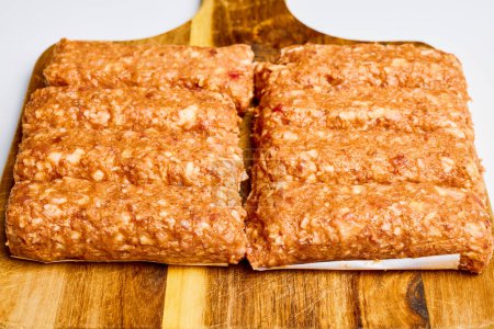 Meat rolls called (small) on a wooden counter, before being cooked, traditional Romanian food.
