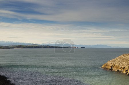 Photo for Coastal part of Cantabria in the north of Spain, Costa Quebrada, ie the Broken Coast, area around Playa de Somocuevas beach, snowy mountains in the distance - Royalty Free Image