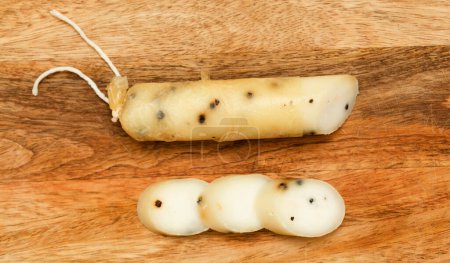 Photo for Produce of Spain - stick of hard goat cheese with whole plack peppercorns produced om Fuerteventura - Royalty Free Image