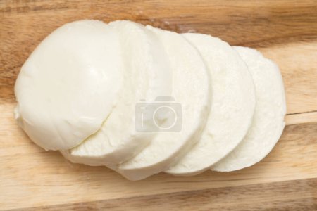 Téléchargez les photos : Boule de mozzarella de buffle tranchée sur une planche de bois - en image libre de droit