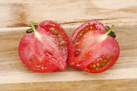 Téléchargez les photos : Tomate rose ronde avec un nez qui produit une forme de coeur lorsqu'il est coupé en deux - en image libre de droit