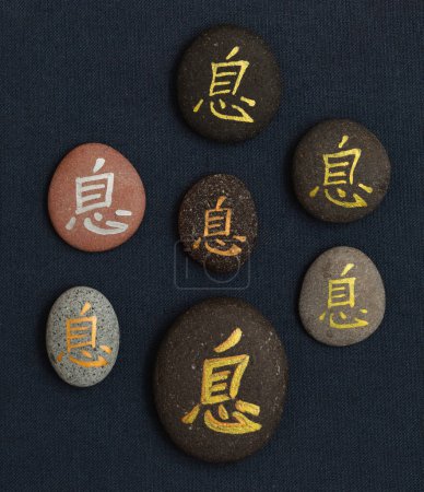 Chinesisches Zeichen xi oder japanisches iki, was Ruhe bedeutet, geschrieben auf Kieselsteinen