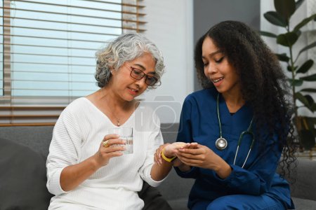 Foto de Enfermera sonriente o cuidadora que explica la dosis del medicamento al paciente mayor. Concepto de medicina y salud. - Imagen libre de derechos