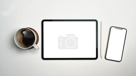 Foto de Tableta digital, teléfono inteligente, lápiz lápiz óptico y taza de café sobre fondo blanco. Pantalla vacía para el diseño de publicidad. - Imagen libre de derechos