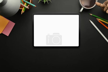 Téléchargez les photos : Espace de travail créatif avec tablette numérique, notes collantes et tasse à café sur table noire. - en image libre de droit