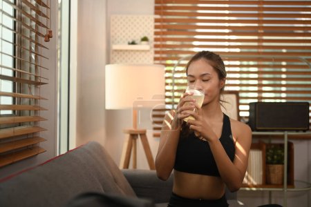 Sporty woman drinking collagen supplements after exercise. Natural supplement for skin beauty and bone health.