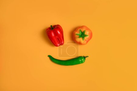 Foto de Pimienta dulce roja, amarilla y chile verde aislado sobre fondo amarillo. Fondo alimentario saludable, concepto vegetal. - Imagen libre de derechos