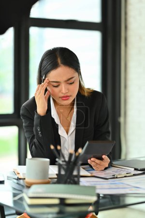 Téléchargez les photos : Femme entrepreneur frustrée tenant sa main se sentant fatiguée et stressée alors qu'elle était assise au bureau. - en image libre de droit